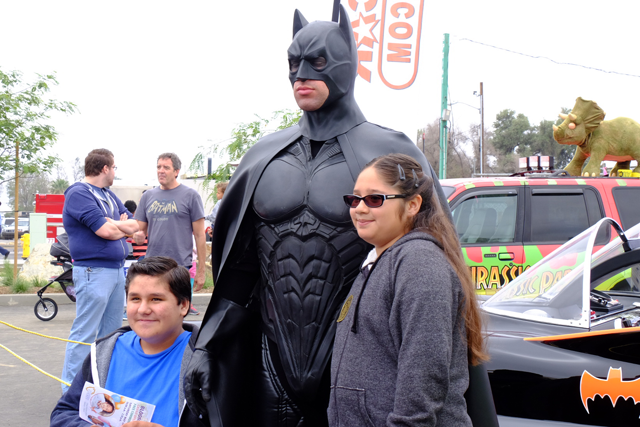 Batman poses for pictures with children at the Bloomington Library Grand Opening